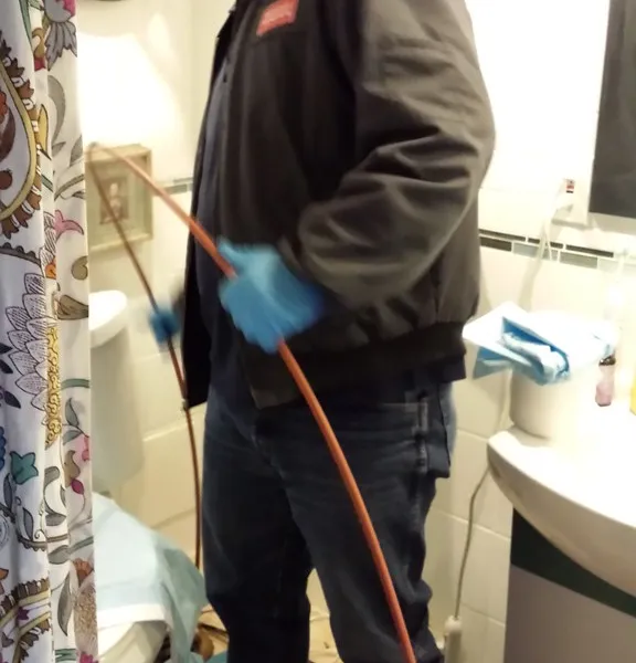 A technician operating drain inspection equipment during a service call